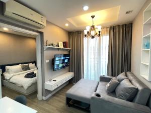 a living room with a couch and a bed and a television at C sky Seaview @The Blu X in Bangsaen