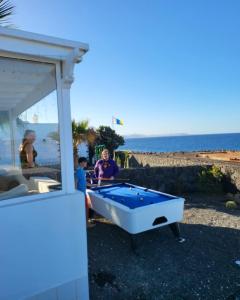 a man and a child playing with a pool table on the beach at Villa Sunset Paradise with panoramic sea view, first line, sunsets in Playa Blanca