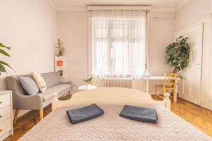 uma sala de estar com uma cama e um sofá em Gellerico Rooms at Horánszky Street em Budapeste