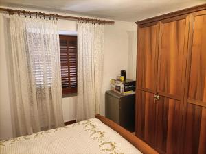 a bedroom with a bed and a large wooden cabinet at A due passi dal Duomo in Cefalù