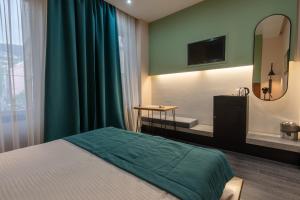 a bedroom with a bed and a bathroom with a mirror at Hotel Astra in Sarajevo