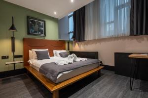 Un dormitorio con una cama con un perro. en Hotel Astra, en Sarajevo