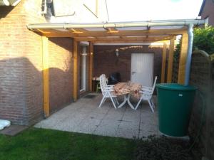 a patio with a table and chairs under a pergola at Ferienhaus "Buchfink" in Berumbur