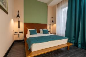 a bedroom with a large bed with blue pillows at Hotel Astra in Sarajevo