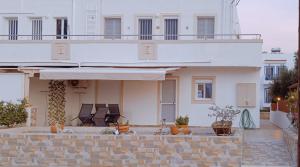 ein weißes Haus mit Balkon darüber in der Unterkunft G.S. Apartment in Mastichari
