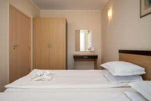 a bedroom with a large white bed and a cabinet at Fantastic holiday apartment at the beach in Obzor +10 photos