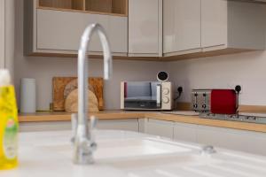 uma cozinha com um lavatório e um micro-ondas em Holbrook house em Cambridge