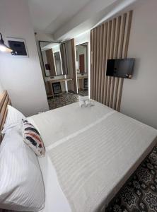 a hotel room with a large white bed with a television at Alaçatı Disa in Alaçatı