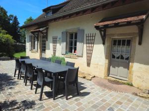 a black table and chairs in front of a house at Le Cottage de Laugère - Gite avec piscine in Charenton sur Cher