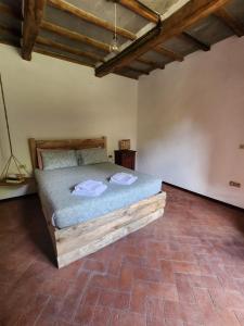 ein Schlafzimmer mit einem Holzbett in einem Zimmer in der Unterkunft Contea del Piano in Piteglio