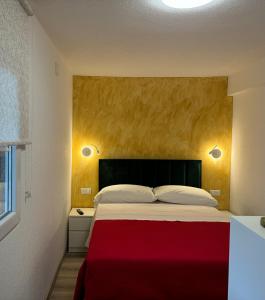 een slaapkamer met een groot bed en een rode deken bij Casa Mare in Rabac