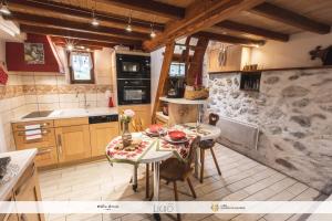 a kitchen with a table and chairs and a sink at gite MOULIN LE PETIT NID in Arcizans-Dessus