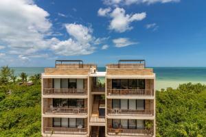 an apartment building with the ocean in the background at Stunning Ocean View Penthouse With Private Pool - B301 in Holbox Island