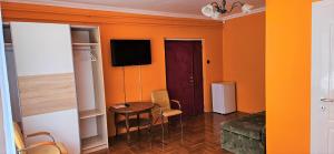 a room with a table and a television in a room at Alex's Hajdúszoboszló in Hajdúszoboszló