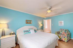 Lorraine's Beach Cottage في كيور بيتش: غرفة نوم بسرير أبيض ومروحة سقف