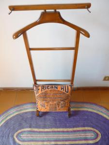 une chaise en bois assise au-dessus d'un tapis dans l'établissement il geranio, à Tirrenia