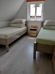 - une chambre avec 2 lits et une fenêtre dans l'établissement Agroturystyka nad Stawem, à Międzygórze
