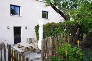 - une table de pique-nique en bois devant une maison blanche dans l'établissement Maison tout confort avec Piscine, à Saint-Martin-de-Londres