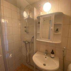 a white bathroom with a sink and a shower at M:Hamn Centrum in Mariehamn