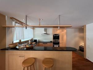Gorgeous Apartment In The Heart Of Zweisimmen في زويسمن: مطبخ مع كونتر و كرسيين