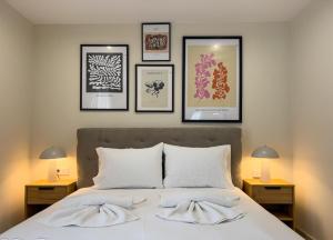 a bedroom with a bed with four pictures on the wall at Loridis Central Apartments in Prinos