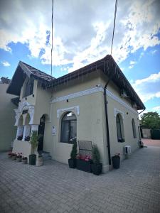 un pequeño edificio blanco con macetas delante de él en PERFECT VILLA Ploiesti, en Ploieşti