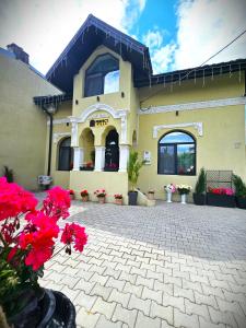 un edificio con flores rojas delante de él en PERFECT VILLA Ploiesti, en Ploieşti