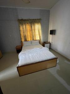 a large bed in a room with a window at Calawazobia Hotel in Uyo