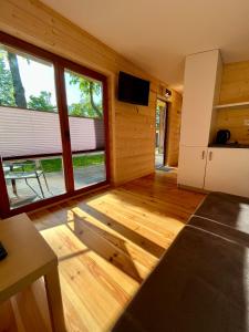 a living room with wooden flooring and large windows at Metropolis Domki in Sopot