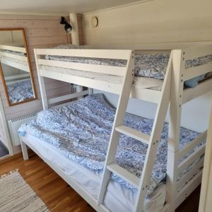 a bedroom with two bunk beds and a mirror at Strandnära boende, Strandbaden in Falkenberg