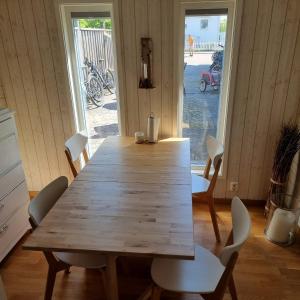 a wooden table with chairs in a room with a window at Strandnära boende, Strandbaden in Falkenberg