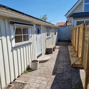 a walkway next to a house and a building at Strandnära boende, Strandbaden in Falkenberg