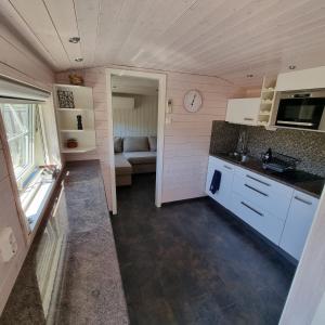 a small kitchen and living room in a tiny house at Strandnära boende, Strandbaden in Falkenberg +4 photos
