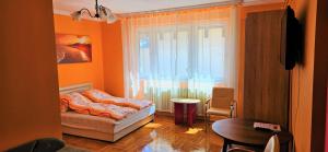 ハイドゥソボスローにあるAlex's Apartman & Panzióのベッドと窓が備わる小さな客室です。