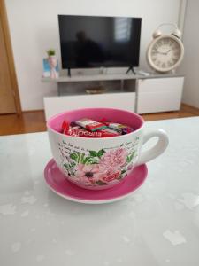 uma chávena de café rosa numa placa cor-de-rosa numa mesa em Apartman NM em Foca