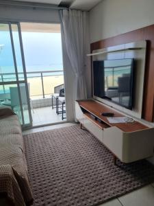 sala de estar con TV y balcón en Terraço do Atlântico en Fortaleza
