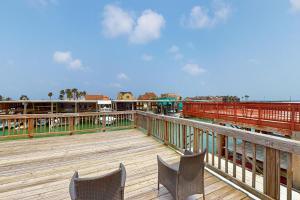 a wooden deck with two chairs on a boardwalk at Sailor's Dream in Port Isabel