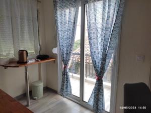una finestra con tende blu in una stanza di Olivia Studios - Melina's home near the sea a Agia Triada
