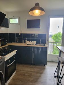 a kitchen with a sink and a stove top oven at Le Temps d'un Séjour Clermont-Ferrand F3 2 chambres 1 chambre avec 1 lit simple et 1 chambre avec 2 lits doubles et 1 Garage in Clermont-Ferrand