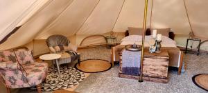 Mouliherne的住宿－Luxury Bell Tent at Camping La Fortinerie，配有带椅子和桌子的帐篷的房间