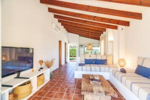 a living room with a couch and a tv at Cal Xoc - Apartamento paradisíaco junto al mar in Son Xoriguer