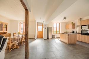 a kitchen and dining room with a table and a kitchen and a dining room at Gîte de la Louvière - maison de campagne in Grandpré