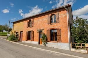 un edificio de ladrillo al lado de una calle en Gîte de la Louvière - maison de campagne, en Grandpré