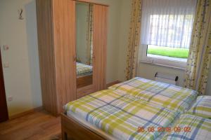 a small bedroom with a bed and a mirror at Ferienwohnung Hau in Kradenbach