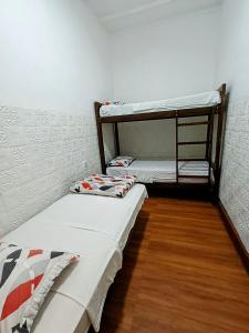 Samanai Wasi Hostel في ليما: سريرين بطابقين في غرفة مع أرضيات خشبية