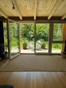een lege kamer met grote ramen en een tapijt bij Your Cozy City Bungalow in Baden