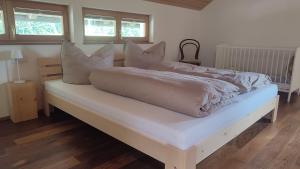 a white bed with pillows on top of it at Landwohnung in Lingenau