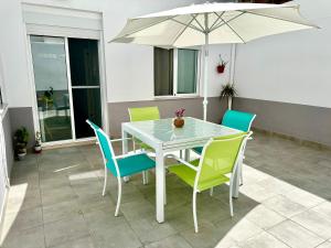 a white table with chairs and an umbrella on a patio at Bonita Planta baja con patio en 1ª línea de playa in Puerto de Sagunto