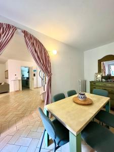 a dining room with a wooden table and chairs at Casa • Paraggi • in Paraggi