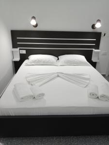a large white bed with two white towels on it at Hotel Villa Ruci in Ksamil